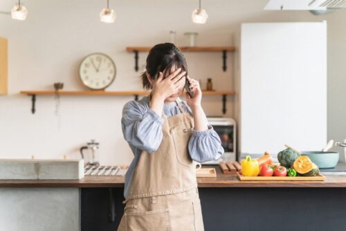 電話をする困った顔の女性